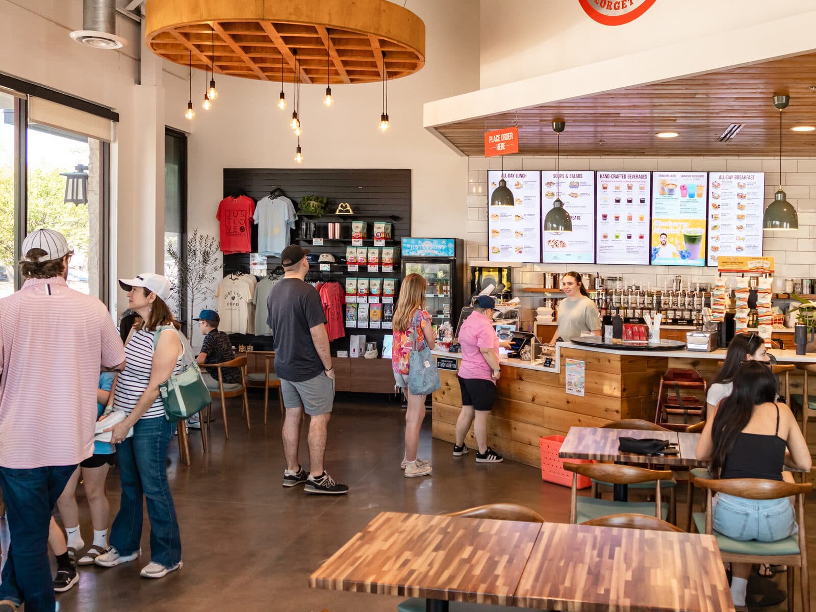 Inside Just Love Coffee & Cafe Georgetown: customers ordering at the counter beneath the menu boards